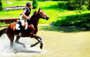 Jeri riding horse through pond