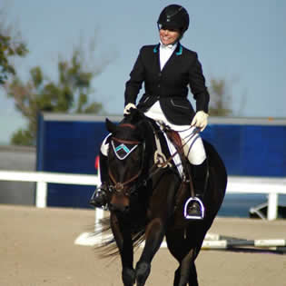 Jeri, smiling, riding horse Oliver back at Octoberfest